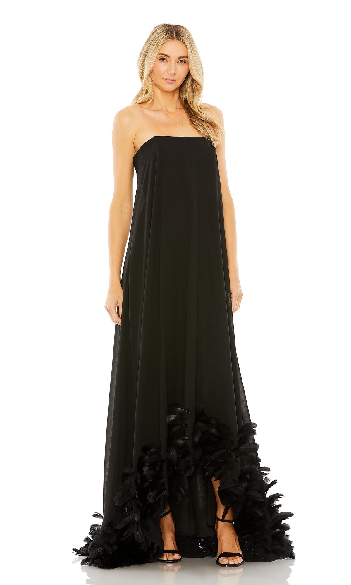 A woman stands facing forward against a white background, wearing the Mac Duggal 13001 Strapless Trapeze Formal Gown with a feathered hem.